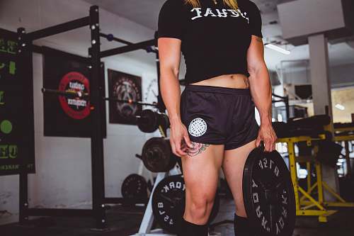 person woman holding black weight plate people