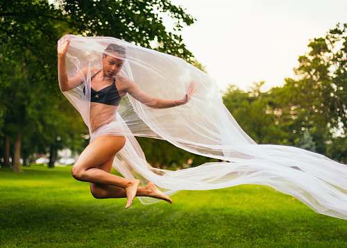 people woman holding mesh cloth while jumping person