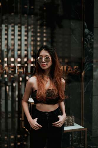 person woman in black crop top standing near establishment people