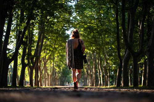 people woman in black dress carrying camera person