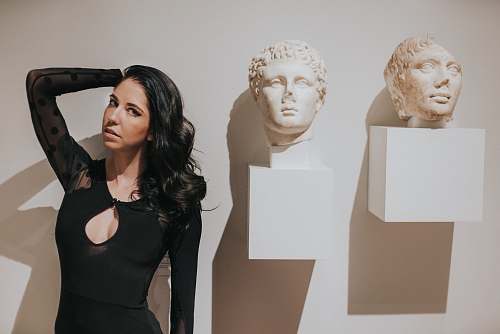 person woman in black dress near wall art