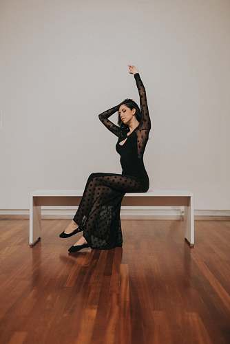 person woman in black long-sleeved dress wood