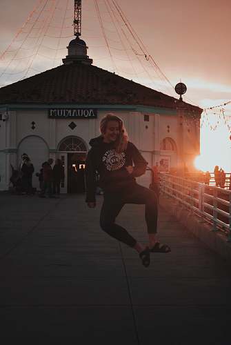 flare woman jumping in front of Aquakjuim building light