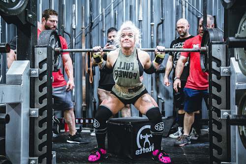person woman lifting barbell people