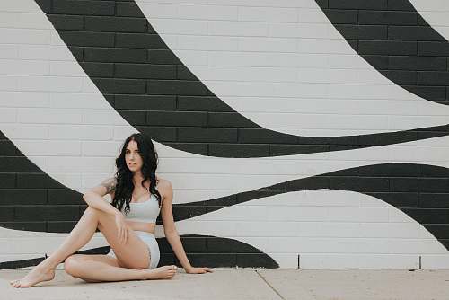 person woman sitting and leaning on wall clothing