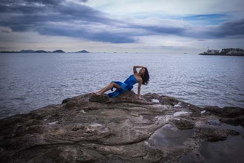 person woman sitting on rock fragment exercise