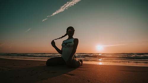 person woman sitting on seashore outdoors