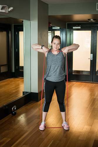 person woman standing and stretching using red rope flooring