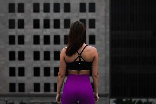 person woman standing in front of gray building during daytime people