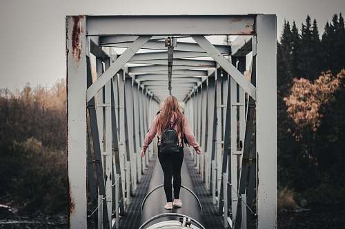 person woman standing on black tunnel at daytime people