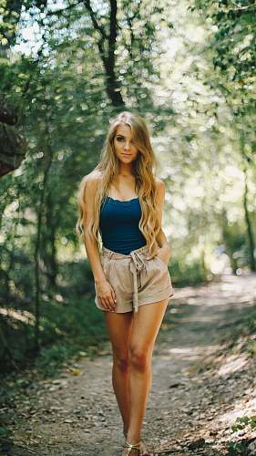 person woman standing on pathway while hand in her pocket people