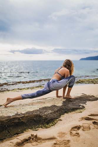 person woman stretching beside body of water yoga