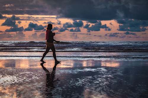 person woman walking along the seashore sport