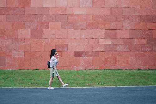 person woman walking on asphalt road people