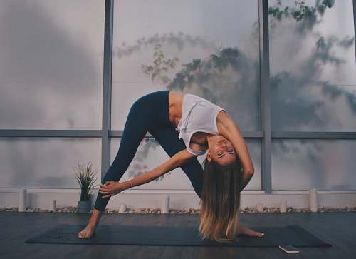 person woman wearing black leggings doing yoga stretch