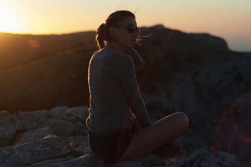 person woman wearing grey sweat shirt and blue denim short shorts sitting on floor with cross leg nature
