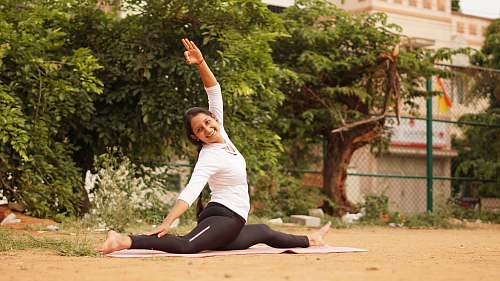 person woman wearing white shirt and black pants exercise