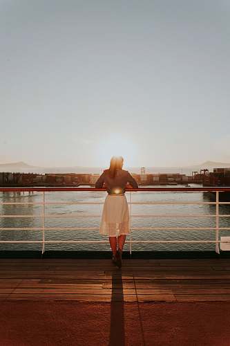 person woman wearing white skirt looking at body of water during daytime people
