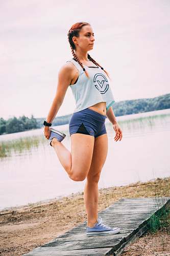 people woman wearing white tank top and blue sport shorts person