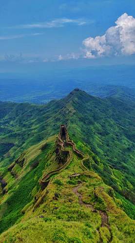 outdoors aerial photography of road viewing mountain under blue and white sky during daytime countryside