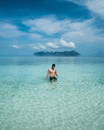 outdoors man in black shorts on blue sea land