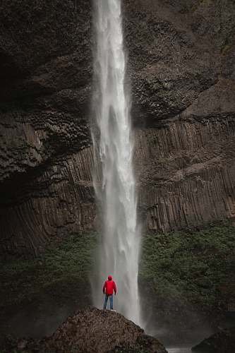eruption man standing near waterfalls geyser