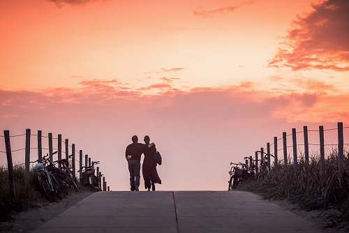 couple man and woman walking on road during dawn scheveningen