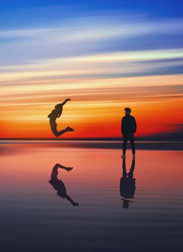 sea man near woman jumping near body of water beach