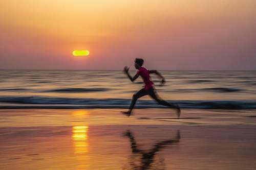 nature man running along seashore during golden hour water