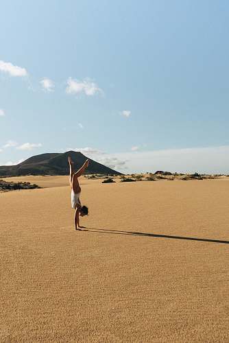 soil woman meditating on desert sand
