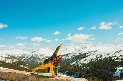 nature woman performing yoga on cliff mountain