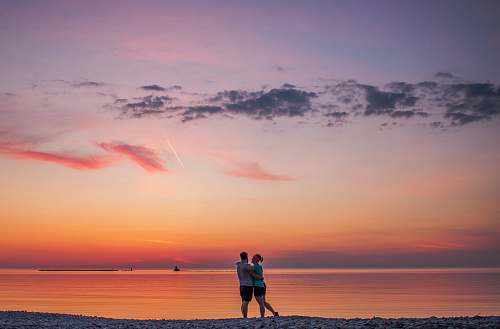 human couple hugging each other near seashore people