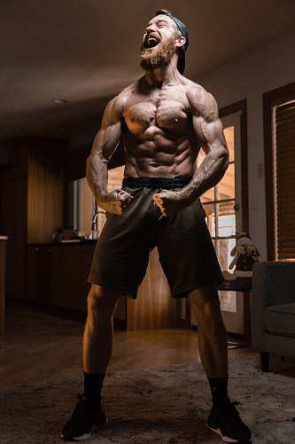 human man flexing muscles wood