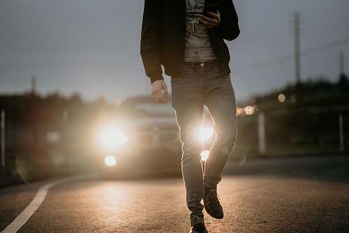 human man in black jacket walking on street people