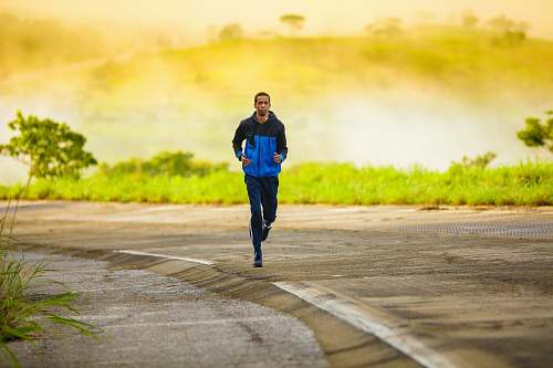 people man in track suit jogging on concrete road man