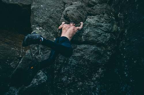 sport man rock climbing on gray rock climb