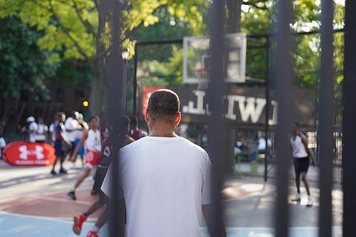 human man sitting on basketball court pedestrian