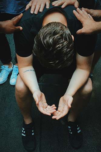human man sitting on chair holding and surrounded by people people