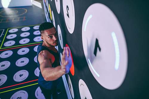 human man wearing black tank top climbing and about to reach number 1 sport