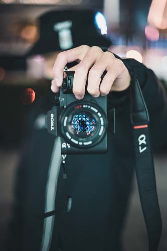 human person holding black Sony Alpha DSLR camera people