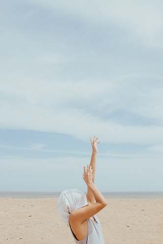 human person rising both hands while covering face at daytime desierto