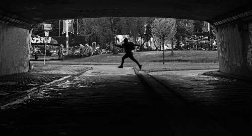human person running on tunnel black-and-white