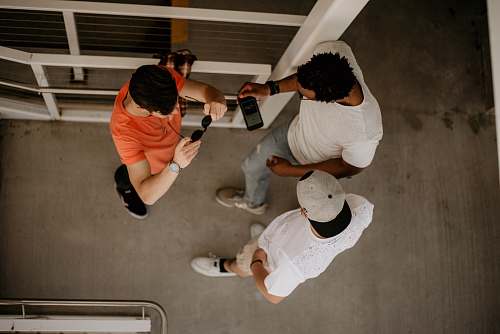 human three men standing beside metal rail clothing