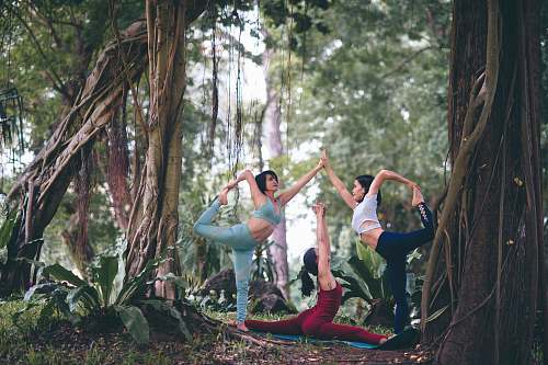 human three women doing yoga at forest people