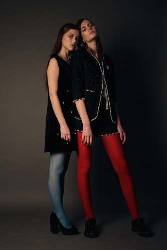 people two women leaning on each other with gray background human