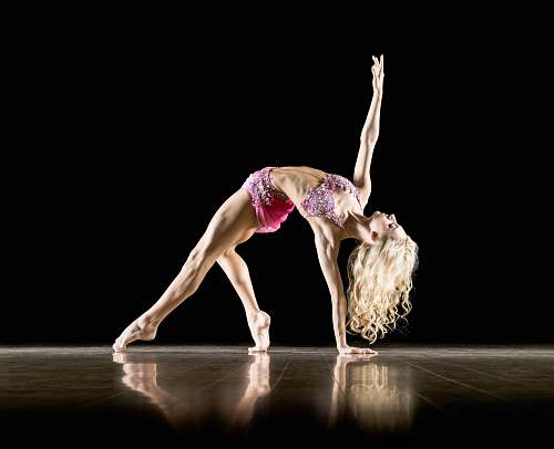 dance woman bending on floor and with black background ballet