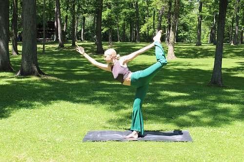 human woman doing yoga exercise outdoor grass