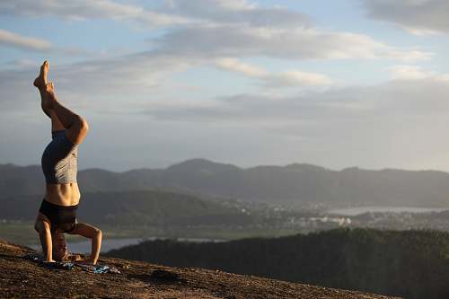 human woman doing yoga on hill exercise