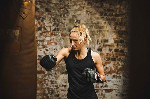 human woman in black tank top wearing boxing gloves sport