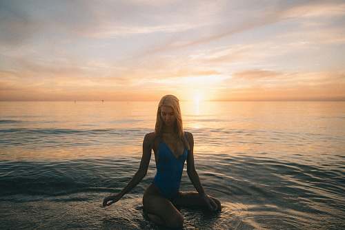 human woman in blue monokini on body of water outdoors
